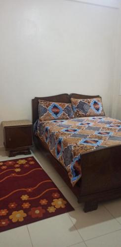 uma cama numa sala com um tapete em إقامة الحمد em Meknès