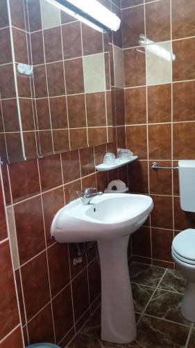 a bathroom with a white sink and a toilet at Hotel Forum in Costinesti