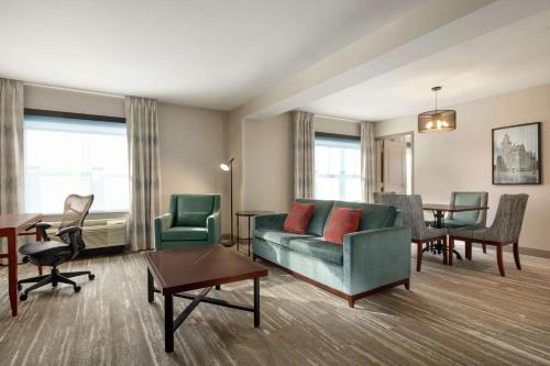 a living room with a couch and chairs and a table at Hilton Garden Inn Troy in Troy