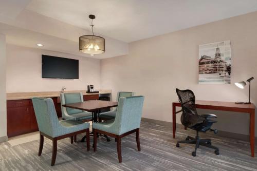 a waiting room with a table and chairs at Hilton Garden Inn Troy in Troy