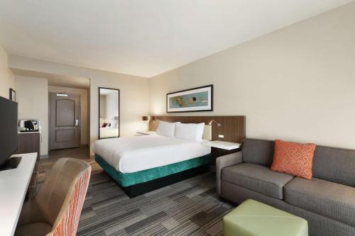 um quarto de hotel com uma cama e um sofá em Hilton Garden Inn Oxford/Anniston, AL em Oxford