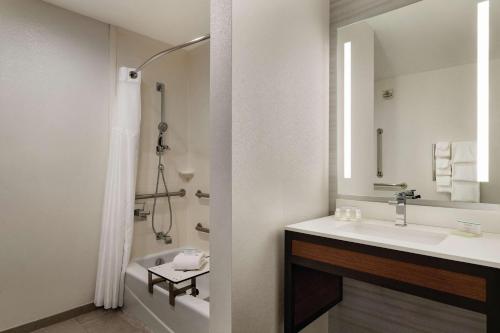 a white bathroom with a sink and a shower at Hilton Garden Inn Oxford/Anniston, AL in Oxford