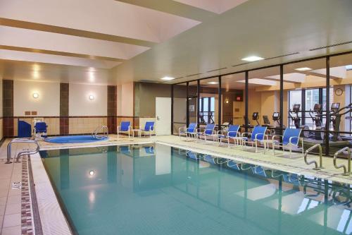 a swimming pool with blue chairs in a building at Hilton Anchorage in Anchorage