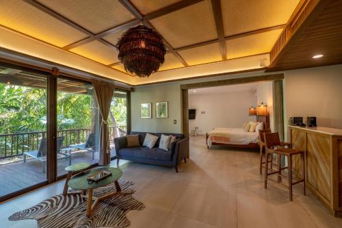 uma sala de estar com uma cama e uma cama e um quarto em Ana y Jose Hotel & Spa Tulum em Tulum