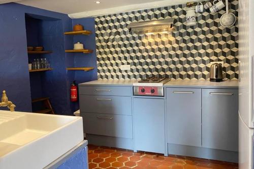 - une cuisine avec des placards bleus et un évier blanc dans l'établissement Luxurious bastidon with swimming pool and jacuzzi, à Lorgues