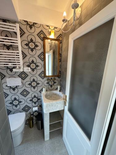 a bathroom with a sink and a toilet and a mirror at Favolosa stanza gialla con terrazzino vista mare Mottino23 in Lerici