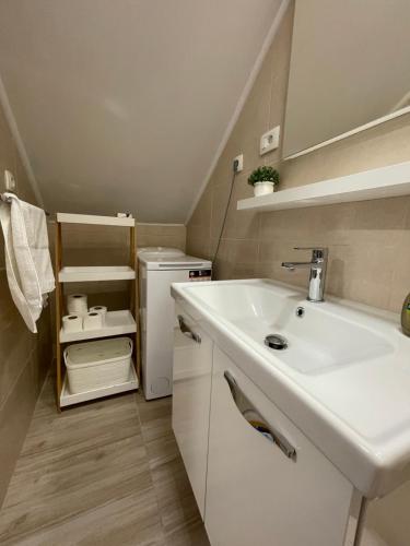 a bathroom with a white sink and a refrigerator at Apartment Sunset in Split