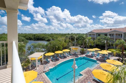 a view of the pool at a resort with yellow umbrellas at DoubleTree Suites by Hilton Naples in Naples
