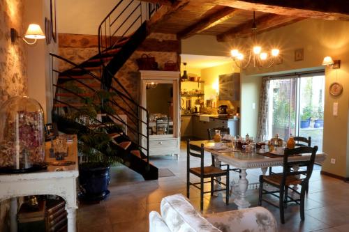 a kitchen and dining room with a table and a staircase at Chambres d’hôtes du Presbytère in La Bastide-lʼÉvêque
