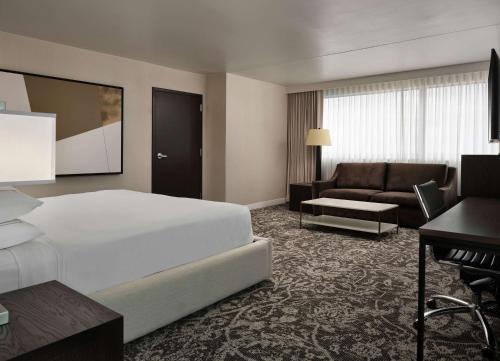a hotel room with a bed and a couch at Hilton Atlanta Airport in Atlanta
