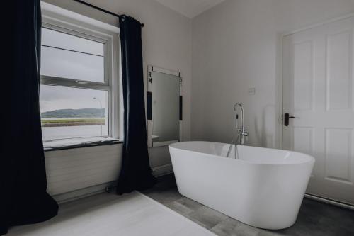 a white bath tub in a bathroom with a window at Sligo Bay Lodge in Rosses Point