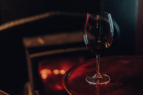 a glass of wine sitting on a table next to a fireplace at Sligo Bay Lodge in Rosses Point