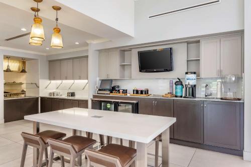 a large kitchen with a white table and chairs at Hilton Garden Inn Atlanta Northeast/Gwinnett Sugarloaf in Duluth