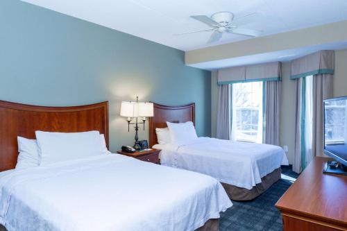 a hotel room with two beds and a flat screen tv at Homewood Suites by Hilton Lawrenceville Duluth in Lawrenceville