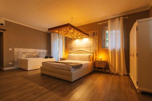 Habitación grande con cama y lámpara de araña. en Agriturismo Agli ulivi, en Saluzzo