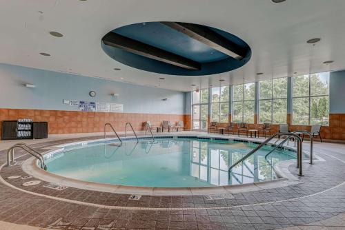 a large swimming pool in a large room with windows at Embassy Suites Atlanta - Kennesaw Town Center in Kennesaw