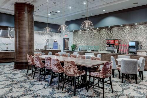 una grande sala da pranzo con un grande tavolo e sedie di Embassy Suites Atlanta - Kennesaw Town Center a Kennesaw