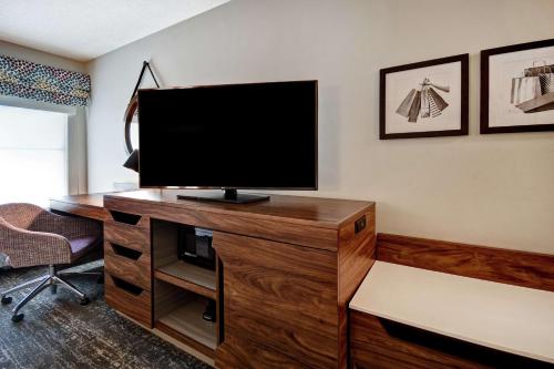 a living room with a television on a wooden desk at Hampton Inn Atlanta-Mall Of Georgia in Buford