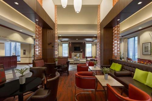 a lobby of a hotel with tables and chairs at Hilton Garden Inn Atlanta Marietta in Atlanta