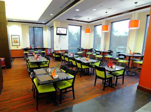 a dining room with tables and chairs and windows at Hilton Garden Inn Atlanta Marietta in Atlanta