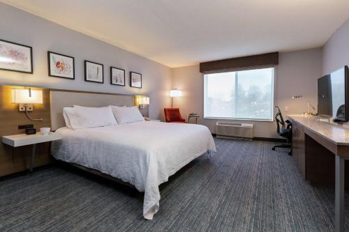 a hotel room with a bed and a large window at Hilton Garden Inn Atlanta Marietta in Atlanta