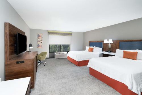 ein Hotelzimmer mit 2 Betten und einem Flachbild-TV in der Unterkunft Hampton Inn & Suites Opelika-I-85 Auburn Area in Opelika