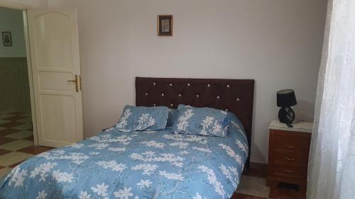 a bedroom with a bed with a blue blanket and pillows at Villa 250 m2 terrasse plus Garage in Mostaganem