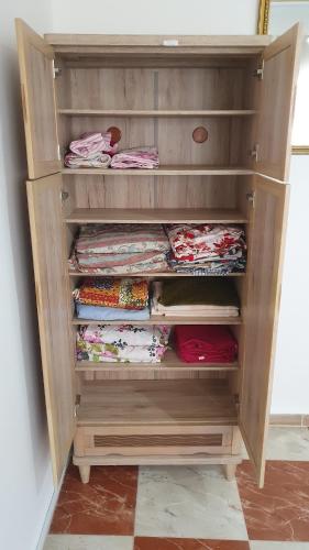 a wooden cabinet with folded shirts in it at Villa 250 m2 terrasse plus Garage in Mostaganem