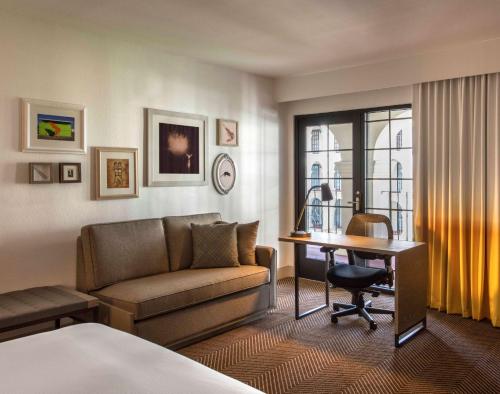 DoubleTree by Hilton Austin في أوستن: غرفة في الفندق مع أريكة ومكتب