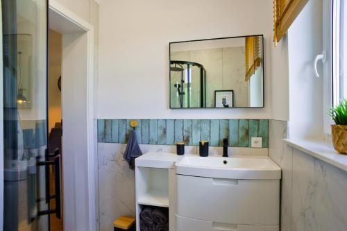 bagno con lavandino bianco e specchio di Domek Zacisze a Uherce Mineralne