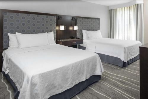 a hotel room with two beds with white sheets at Homewood Suites by Hilton Columbia in Columbia