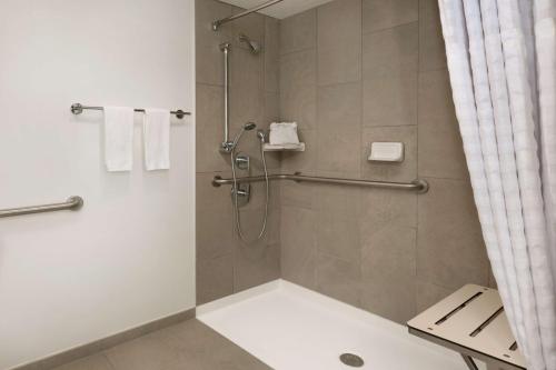 baño con ducha y puerta de cristal en Embassy Suites Boca Raton, en Boca Raton