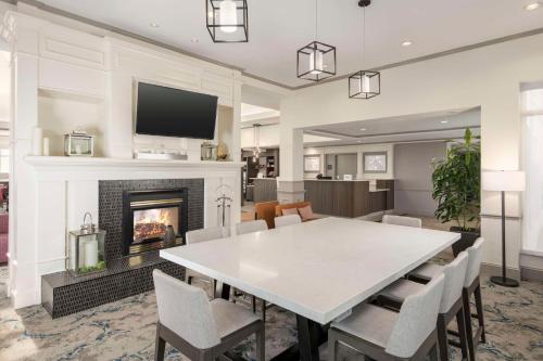 a dining room with a table and a fireplace at Hilton Garden Inn Boca Raton in Boca Raton