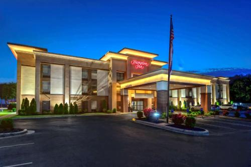 un hotel con bandera americana en un estacionamiento en Hampton Inn Batesville, en Batesville