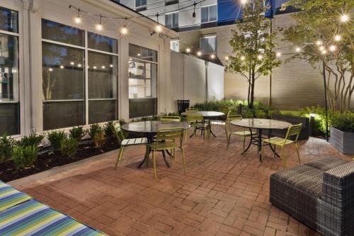 a patio with tables and chairs in a building at Hilton Garden Inn Birmingham/Lakeshore Drive in Birmingham