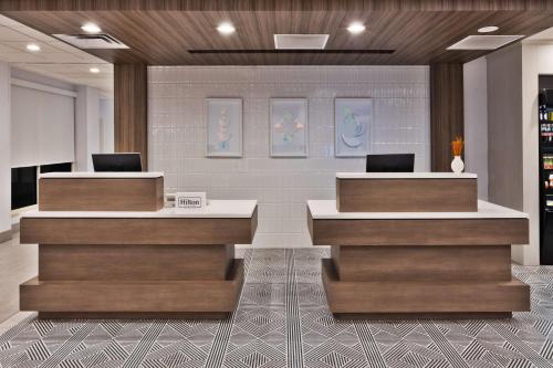 a lobby with two reception desks with laptops on them at Hilton Garden Inn Birmingham/Lakeshore Drive in Birmingham