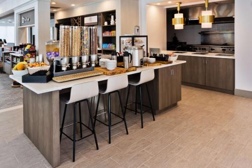 a kitchen with a large counter with bar stools at Hilton Garden Inn Birmingham/Lakeshore Drive in Birmingham