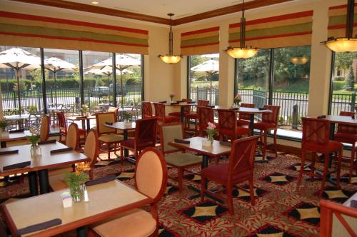 a restaurant with tables and chairs and windows at Hilton Garden Inn Bowling Green in Bowling Green