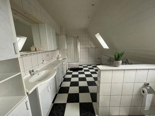 a bathroom with a sink and a black and white checkered floor at Behagliches Haus mit Kamin in Rechtsupweg