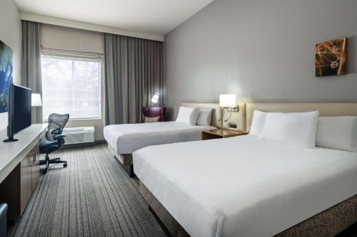una camera d'albergo con due letti e una televisione di Hilton Garden Inn Bakersfield a Bakersfield
