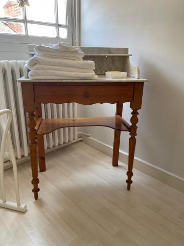 a wooden table with a pile of towels on it at Belle Fontaine in Bourges