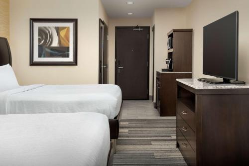 a hotel room with two beds and a flat screen tv at Hilton Garden Inn Murfreesboro in Murfreesboro