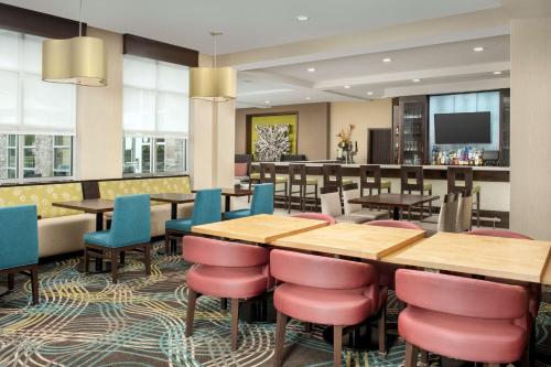 a restaurant with tables and chairs and a bar at Hilton Garden Inn Murfreesboro in Murfreesboro