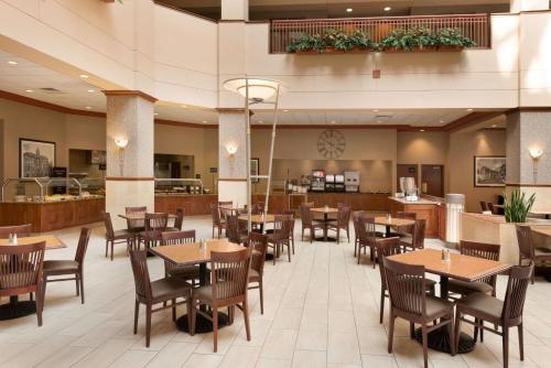 Un restaurante con mesas y sillas y un bar. en Embassy Suites by Hilton Franklin Cool Spring, en Franklin