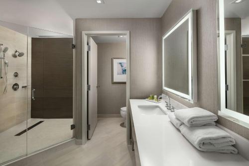 a bathroom with a toilet and a sink and a shower at Hilton Boston Logan Airport in Boston