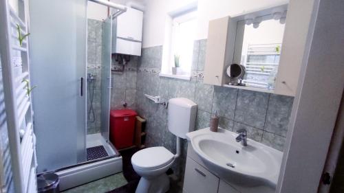a bathroom with a toilet and a sink and a shower at Kuća za odmor Proljeće in Đakovo