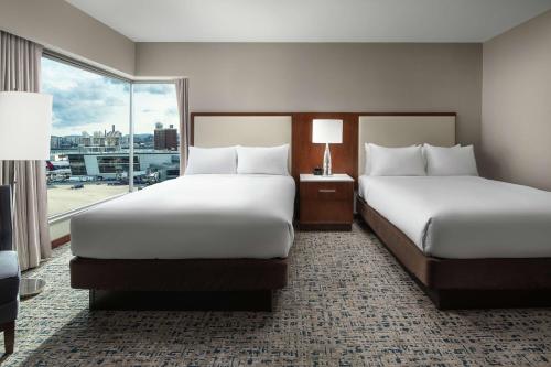 two beds in a hotel room with a window at Hilton Boston Logan Airport in Boston