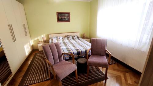 a bedroom with a bed and two chairs at Kuća za odmor Proljeće in Đakovo
