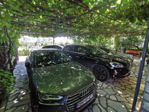 two cars are parked under a pergola at Bar-Apartman 2 in Bar