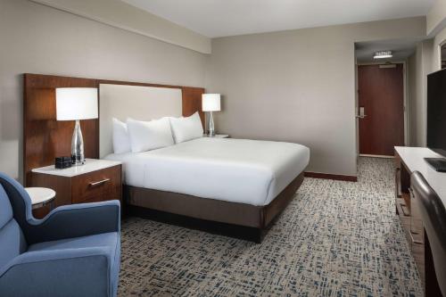 a hotel room with a bed and a blue chair at Hilton Boston Logan Airport in Boston